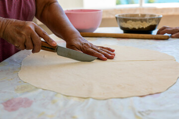 The woman making meaty ravioli ( Turkish: manti ). Manti in Central Asian cuisines are usually larger in size. They are steamed in a multi level metal steamer called mantovarka, mantyshnitsa.	