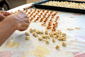The woman making meaty ravioli ( Turkish: manti ). Manti in Central Asian cuisines are usually larger in size. They are steamed in a multi level metal steamer called mantovarka, mantyshnitsa.	