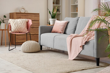 Interior of living room with sofa, knitted plaid and chair