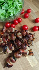 Deliciously grilled skewers featuring tender meat and vegetables with fresh greens and cherry tomatoes on a wooden surface