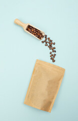 High-angle flat lay of a scoop pouring coffee beans into a paper eco bag, designed for commercial and editorial content
