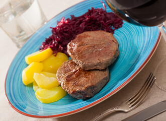 Veal Medallion de cadera with potato and sauerkraut..Healthy roasted beef steak served with baked potatoes and pickled cabbage..Grilled veal steak with boiled potato and marinated cabbage
