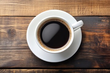 A cup of black coffee on a wooden table.  Dark, rich, and hot coffee in a white cup and saucer.  Aromatic steam rises from the cup