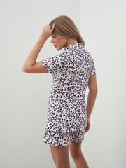 Blonde woman posing in colorful pajamas against simple background