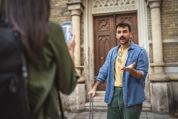 woman record a video of man tourist blogger explain landmark