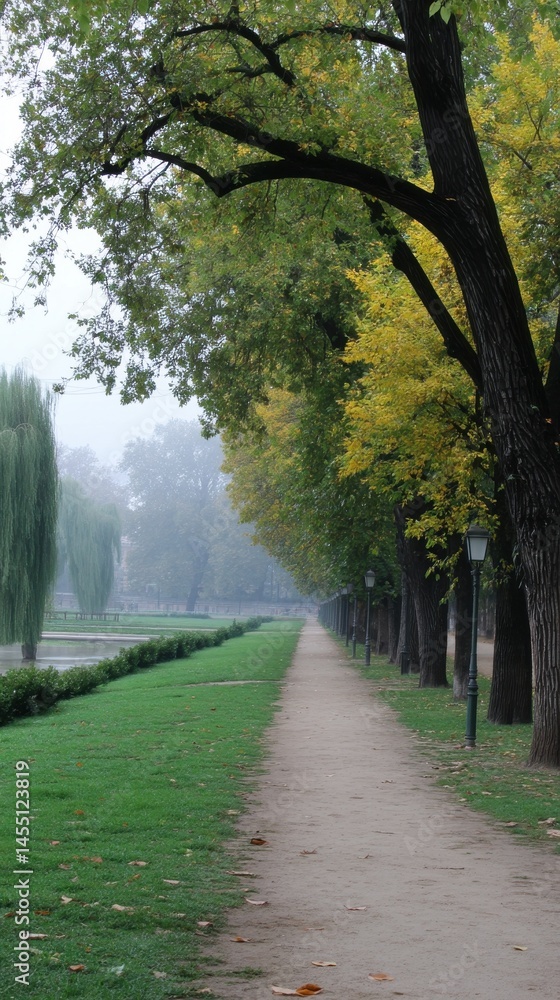 Poster tranquil autumn pathway through a park lined with trees and lampposts in soft, diffused light and mi