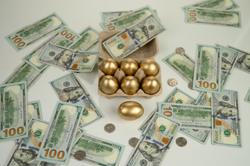 Golden eggs against a background of scattered dollars.