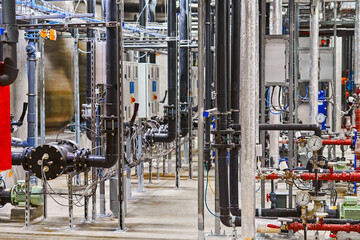 Detailed Interior View of a Complex Industrial Piping and Plumbing System within a Manufacturing Facility.