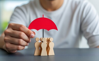 Symbol of Security: A protective red umbrella shelters a group of wooden figures. A visual representation of safety, security, and support. Emphasizing protection, insurance and care.