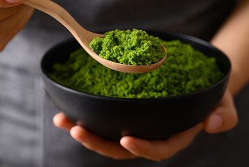 Wolffia or watermeal in bowl and spoon holding by hand, Healthy edible small aquatic plant high protein and fiber