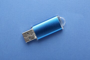 One flash drive on blue background, top view