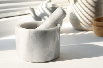 Marble mortar and pestle on windowsill indoors, closeup. Space for text