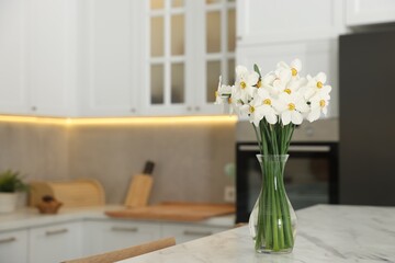 Beautiful daffodils in vase on white marble table indoors, space for text