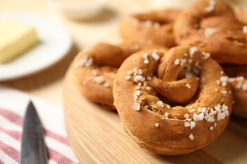 Tasty pretzels with salt on table, closeup