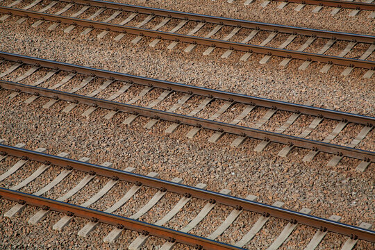 Multiple parallel railway tracks with gravel ballast, captured in sunlight. Infrastructure concept, transport and travel background