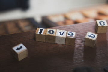 Wooden alphabet blocks spelling love on rustic wooden table.