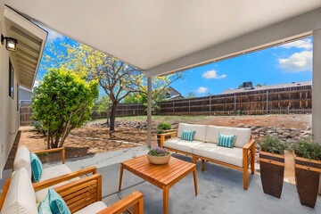 A cozy patio with couch, chairs, table, and potted plants