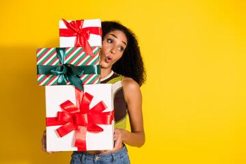 Young woman excitedly holding gift boxes in a colorful setting celebrating festive occasions with...