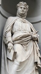 Obraz premium Florence, Italy - 3 January 2025. Statue of Francesco Petrarca (Petrarch) by Luigi Ferrari, completed in 1856, with the crowned poet holding a book, located in a niche at the Piazzale degli Uffizi.