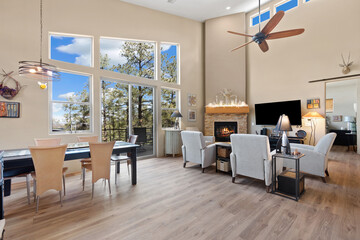 A cozy living room featuring a ceiling fan and a warm fireplace