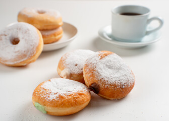 Powdered jelly-filled donuts with creamy fillings on white background – sweet pastry dessert perfect for bakery, breakfast, recipes, articles, snack-theme or any cooking content.