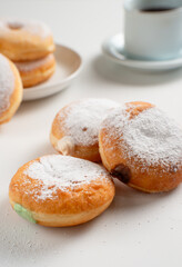 Powdered jelly-filled donuts with creamy fillings on white background – sweet pastry dessert perfect for bakery, breakfast, recipes, articles, snack-theme or any cooking content.