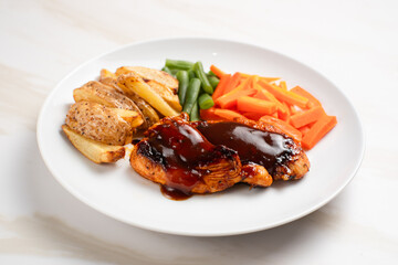 Grilled chicken steak with barbecue sauce, potato wedges, and fresh vegetables. Perfect for healthy lunch, dinner menu content, recipes, articles or any cooking content