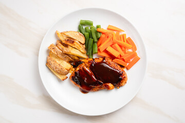 Grilled chicken steak with barbecue sauce, potato wedges, and fresh vegetables. Perfect for healthy lunch, dinner menu content, recipes, articles or any cooking content