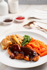 Grilled chicken steak with barbecue sauce, potato wedges, and fresh vegetables. Perfect for healthy lunch, dinner menu content, recipes, articles or any cooking content