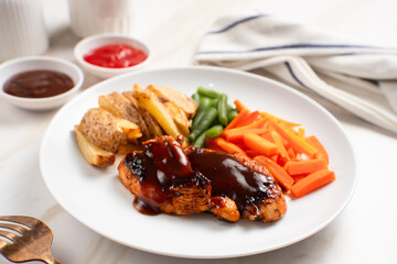 Grilled chicken steak with barbecue sauce, potato wedges, and fresh vegetables. Perfect for healthy lunch, dinner menu content, recipes, articles or any cooking content