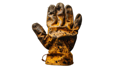 overhead photo of a single gardening glove with natural soil smudges isolated 