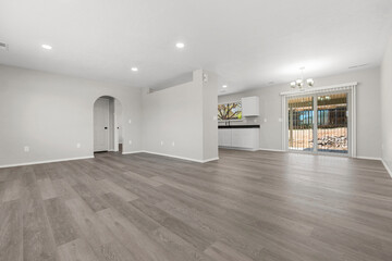 A spacious living room with hardwood floors and white walls