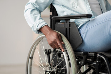 Obraz premium Hospital for service patient and disabled people. Medical equipment in clinic for assistance handicapped people. African american man in chair with wheels for patient care at home, focus on hand