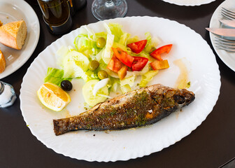 Delicious fish dish, grilled bass with vegetables and green sauce