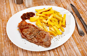 Tasty grilled beef tenderloin with french fries served at plate