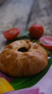 Mongolian buuz, dumplings with meat, savory fried dumplings filled with juicy meat, served on a plate with herb, arugula, tomatoes. Artisanal food