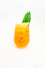 orange citrus cocktail with tropical leaf garnish served in transparent glass over ice on clean white background. High quality photo