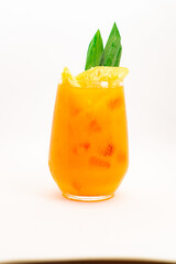orange citrus cocktail with tropical leaf garnish served in transparent glass over ice on clean white background. High quality photo