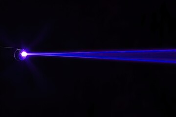 Bright purple laser beam emitting from a small light source,  against a black background