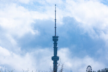 Obraz premium Panorama of the TV tower and the city of Almaty in early spring. Flight over the hills with a view of the mountain, the Koktobe tower and the city of Almaty.