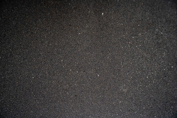 Close-up of dark textured sand surface