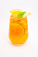 refreshing orange citrus cocktail with sliced lemon and mint leaves served in clear glass over ice on white background. High quality photo