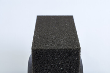 Texture of black tire shine foam applicator pad sponge close-up isolated on white background