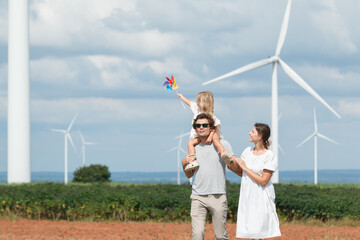 Western family enjoying a walk through a wind turbine field. © DG PhotoStock