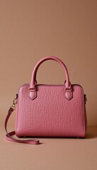 An elegant pink leather handbag with a top handle and shoulder strap rests against a textured tan background, showcasing its simple and sophisticated style.