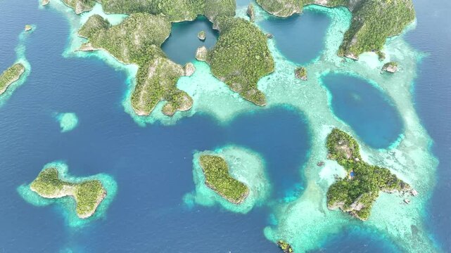 Rock islands rise from the beautiful seascape in Misool, Raja Ampat, Indonesia. This area is known as the heart of marine biodiversity and is a popular destination for diving and snorkeling.