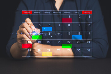 Close-up of hand managing colorful agenda on virtual calendar screen for time management.