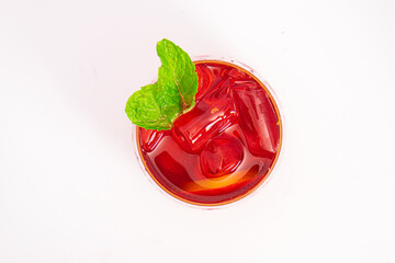 vibrant red citrus cocktail with blood orange slice and fresh mint served in clear glass over ice...