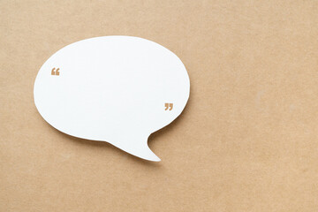 blank real speech bubble white paper cut with quotation marks on grunge brown paper background