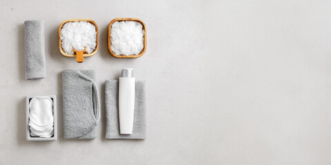 Top view banner  Spa or bath accessories on grey background. Sea salt, cotton towels, natural...